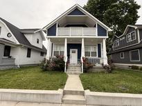 Charming two-story home featuring a covered front porch, white columns, and a well-maintained lawn with flowers at 1720 Rembrandt St, Indianapolis, IN 46202