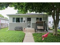 Charming single-story home with a cozy front porch and swing, nestled under the shade of a mature tree at 219 N 9Th Ave, Beech Grove, IN 46107