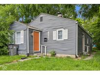 Charming home featuring grey siding, an orange front door, well-kept lawn and an inviting curb appeal at 2359 N Gale St, Indianapolis, IN 46218