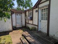 View of exterior side of house, showing multiple doors and peeling paint at 489 W Sumner Ave, Martinsville, IN 46151