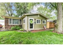 Charming single-story home features a vibrant green exterior, inviting front yard, and classic brick accents at 504 Broadway Ave, Arcadia, IN 46030