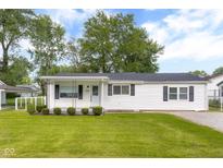 Charming single-story home with a well-maintained lawn and mature trees under a sunny, partly cloudy sky at 533 Patterson Rd, Columbus, IN 47203