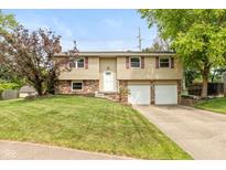 Charming two-story home features a manicured front lawn and attached two car garage at 5802 Rymark Ct, Indianapolis, IN 46250