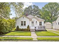 Charming home featuring a well-kept lawn, inviting front porch, and beautiful, traditional architectural details at 6045 Crittenden Ave, Indianapolis, IN 46220