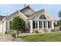 Charming brick home featuring a well-manicured lawn, trimmed shrubs, and a cozy front porch at 7357 Lake Lakota Dr, Indianapolis, IN 46217