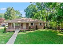 Charming brick ranch home with a well-manicured lawn and inviting walkway at 802 Lawrence Ave, Indianapolis, IN 46227