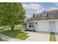 Charming home featuring an attached garage and a beautifully landscaped yard with mature trees at 8247 Cape N Dr, Indianapolis, IN 46256
