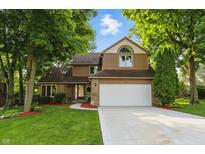 Charming two-story home with a well-manicured lawn and mature trees shading the front yard at 8313 Tequista Cir, Indianapolis, IN 46236