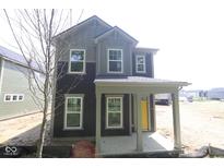 Charming two-story home with a covered porch and a yellow front door at 9516 Bauhaus Way, Indianapolis, IN 46240