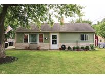 Charming single-story home featuring green siding, a manicured lawn, and lovely landscaping at 103 Bentwood Dr, Greenwood, IN 46143