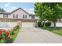 Charming two-story home with a well-manicured lawn, attached garage, and delightful red roses at 1138 Topp Creek Dr, Indianapolis, IN 46214