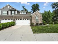 Beautifully landscaped two-story home with a brick and stone facade and a pristine two-car garage at 14474 Treasure Creek Ln, Fishers, IN 46038