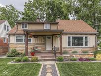 Charming home with a stone facade, covered porch, and manicured lawn at 1532 E Markwood Ave, Indianapolis, IN 46227