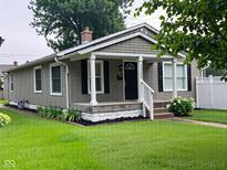 Charming single story home featuring a covered porch and manicured lawn at 1556 N Euclid Ave, Indianapolis, IN 46201