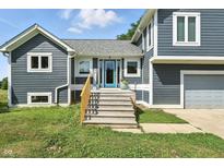 Charming gray two-story home with a blue front door and wooden steps at 17138 Joliet Rd, Westfield, IN 46074