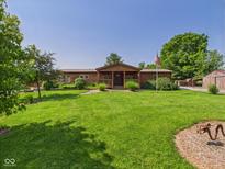 Inviting log home featuring a sprawling lawn, charming front porch, and lush landscaping at 2895 E 600 S, Markleville, IN 46056