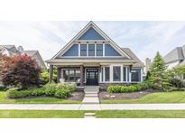 Charming home with blue shingles, stone accents, manicured lawn, and inviting curb appeal at 3429 Woodham Pl, Carmel, IN 46033