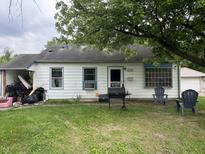Exterior view of home with white siding, grill, and chairs on the front lawn at 3440 Brewer Dr, Indianapolis, IN 46222