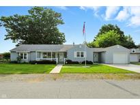 Charming single-story home featuring a well-maintained lawn, light blue siding, and a cozy front porch at 409 Hanley St, Plainfield, IN 46168