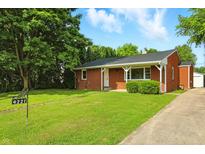 Charming brick home with a well-manicured lawn and inviting front porch at 4221 Haverhill Dr, Anderson, IN 46013