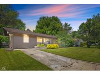 Charming single-story home with stone and wood accents, landscaped yard, and concrete driveway at 4742 Kingsley Dr, Indianapolis, IN 46205