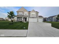 Charming two-story home with a well-manicured lawn and a three car garage at 6842 Arrowhead Dr, Brownsburg, IN 46112