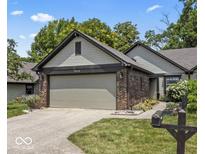 Charming home featuring a two-car garage, beautiful brick accents, and a well-maintained lawn at 7616 Derrek Pl, Indianapolis, IN 46219
