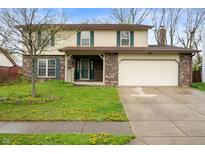 Charming two-story home with a well-manicured lawn and inviting curb appeal on a sunny day at 8306 Corkwood Dr, Indianapolis, IN 46227