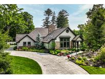 Charming home featuring stone and shingle exterior, lush landscaping, stamped driveway and inviting entrance at 8651 Emerald Ln, Indianapolis, IN 46260