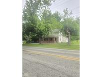 Traditional two-story home with a brick porch and mature trees providing shade and curb appeal at 9024 W Mooresville Rd, Indianapolis, IN 46113