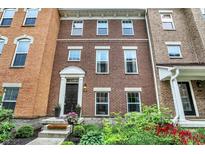 Charming brick townhome featuring a welcoming entrance and well-maintained landscaping at 9508 Oakley Dr, Indianapolis, IN 46260