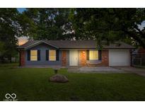 Charming single story home with brick and gray siding, attached garage and a green lawn at 9526 Burrwood Ct, Indianapolis, IN 46235