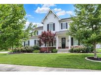 Charming two-story home with a manicured lawn, mature trees, and classic black and white design at 10805 Solis Cir, Fishers, IN 46038