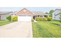 Charming brick home featuring a two-car garage, well-maintained lawn, and inviting front porch at 2402 Foxtail Dr, Plainfield, IN 46168