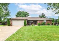 Charming brick home with a well-manicured lawn, attached garage, and inviting front porch at 4080 Wander Way, Greenwood, IN 46142