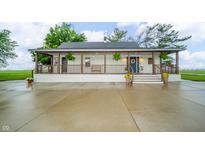 Charming home featuring a covered porch with wood beams and a welcoming blue front door at 4491 W 600 N, Anderson, IN 46011