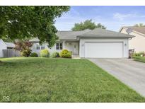 Charming single-story home with a well-manicured lawn and attached two-car garage on a sunny day at 5986 Regency Dr, Columbus, IN 47203