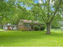 Charming brick home with a well-manicured front yard and mature trees for ample shade and curb appeal at 7928 Vontress St, Coatesville, IN 46121
