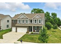 Inviting two-story home with brick and siding exterior, complemented by a well-manicured lawn and a two-car garage at 10113 Gallop Ln, Fishers, IN 46040