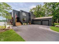 Modern home featuring dark siding, an attached three-car garage, and manicured landscaping at 121 Wesley Cir, Noblesville, IN 46062