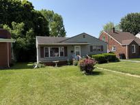 Charming one-story home with a well-maintained lawn and classic curb appeal on a sunny day at 1227 W 9Th St, Anderson, IN 46016