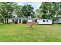 Charming single-story home with a green metal roof, fresh white paint, and a well-maintained lawn at 12471 N 100 E, Alexandria, IN 46001