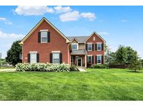 Charming brick two-story home featuring a lush green lawn and beautiful hydrangeas at 13191 Roma, Carmel, IN 46074