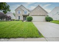 Charming two-story home featuring a brick facade, lush lawn, and attached two-car garage at 16095 Tenor Way, Noblesville, IN 46060