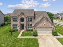 Traditional two-story brick home featuring an attached garage and manicured lawn at 2078 Seneca Ln, Plainfield, IN 46168