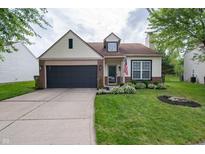 Charming home featuring an attached garage, lush lawn and manicured landscaping at 4238 Victory Ct, Indianapolis, IN 46203