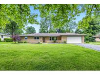Charming single-story home with an attached garage, well-maintained lawn, and mature landscaping at 5205 Staughton Dr, Indianapolis, IN 46226