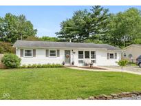 Charming single-story home with a well-manicured lawn and inviting curb appeal with beautiful trees in the background at 544 Everling Dr, Morgantown, IN 46160