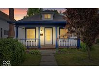 Charming home featuring a cozy front porch with classic blue columns and a well-manicured lawn at 57 E South St, Mooresville, IN 46158