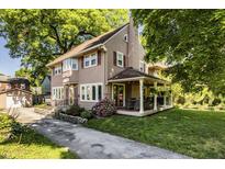 Charming two-story home with a covered porch, landscaped yard, and private driveway at 5760 Central N Ave, Indianapolis, IN 46220